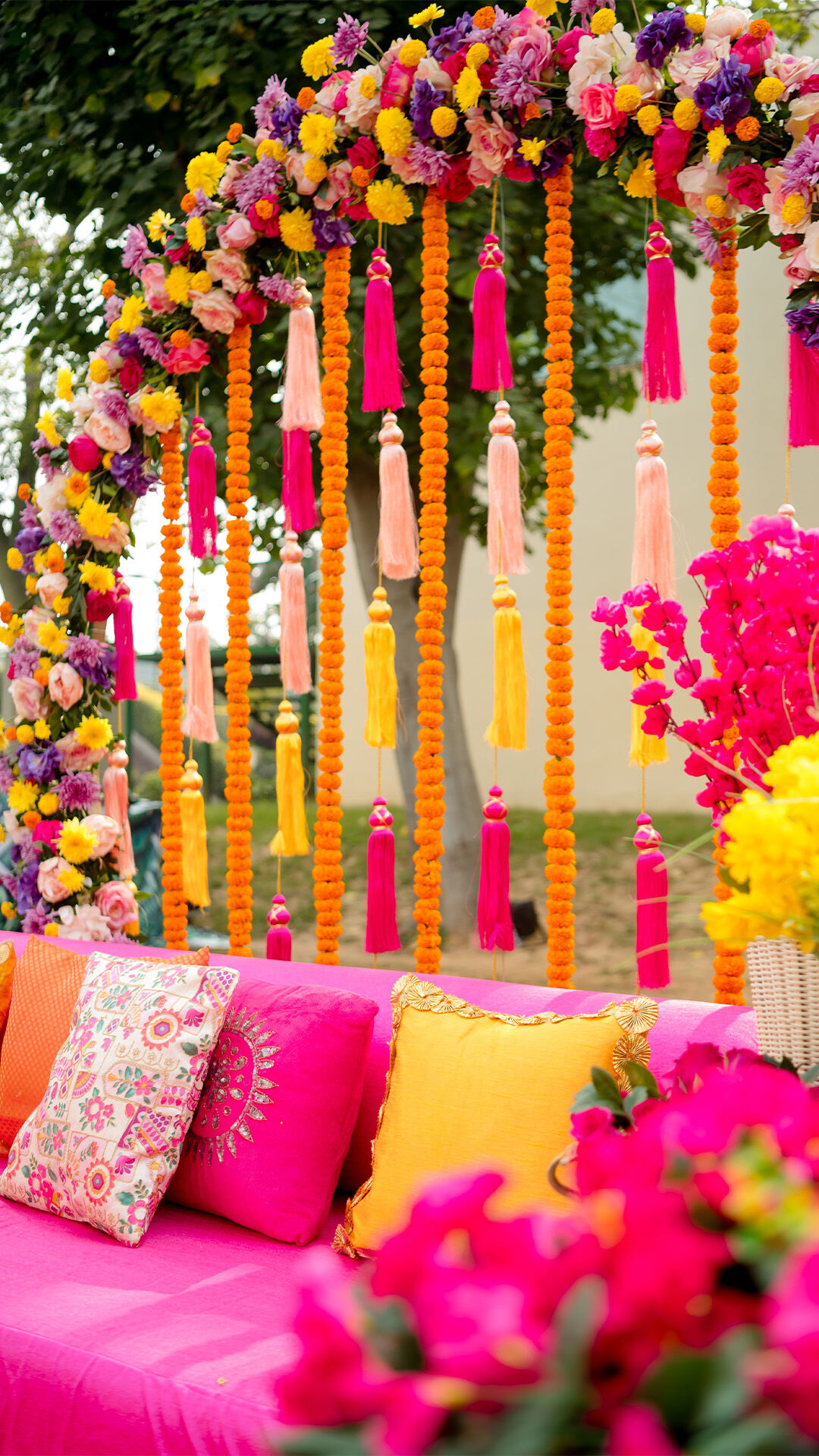Stunning mehendi setup featuring colorful flowers and elegant decor accents.